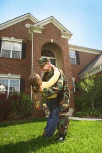 military family happy in front of home